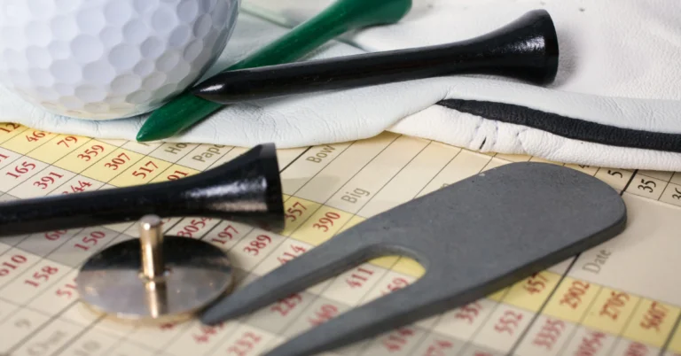 Golf accessories lying on top of a score card.