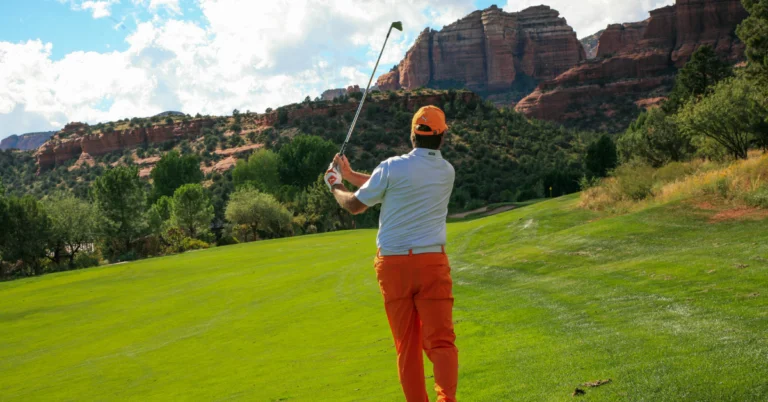 Man watching his golf shot against the stunning backdrop of a Sedona golf course in Arizona.